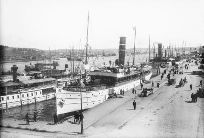 Hamnen med stort antal båtar, bl a Oihonna, Heffners sågar i bakgrunden, 1910. Båtar (bogserbåtar, passagerarbåtar, last och segelfart. Sundsvall