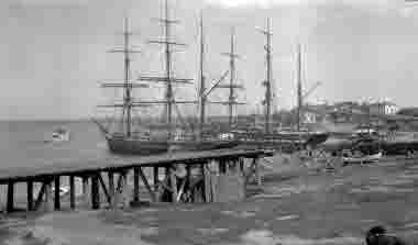 Hamnen med segelskutor och samhället i bakgrunden, 1920. Holmsunds sågverk