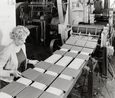 Plastgolvfabriken, interiör från tillverkningen, plattorna kommer ur stansmaskinen och sorteras och kontrolleras, 1957. Holmsundsindustrierna (plast, snickeri, lamellgolv)