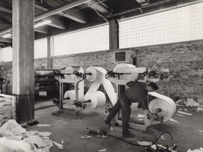 Från 1958-59 vid starten av PM 1 och PM 2. Det var naturligtvis stora problem och svårigheter i början, dels att få veden barkad riktigt, upparbetning till fibrer i slipstolar var också besvärligt. Det blev ofta rynk i pappersbanan, beroende på att kåpan över torkcylindrarna saknade sidoväggar, och sneddrag av arket uppstod. För att det inte skulle komma ut papper med dålig kvalité på marknaden skedde en stor urgallring. En stor del konverterades till ark som sorterades av kvinnlig personal. Pappersarken räknades till ”ris”, 500 ark/paket som sedan lades ihop till en bal-form. Försågs med träskydd på sidorna och bandades. Träskydden gjordes av Sundsvalls fönsterfabrik, SCA-ägt. SCA exporterade balarna till bla.a. Janer Sydamerika. Rullmaskiner, omrullningsmaskin och arkmaskiner var av typ Jagenberg. Denna bild visar pappersmaskinens bakre del, maskinförare Valter Pettersson.