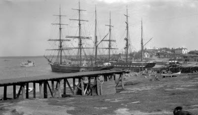 Hamnen med segelskutor och samhället i bakgrunden, 1920. Holmsunds sågverk var i drift från 1896-2013.